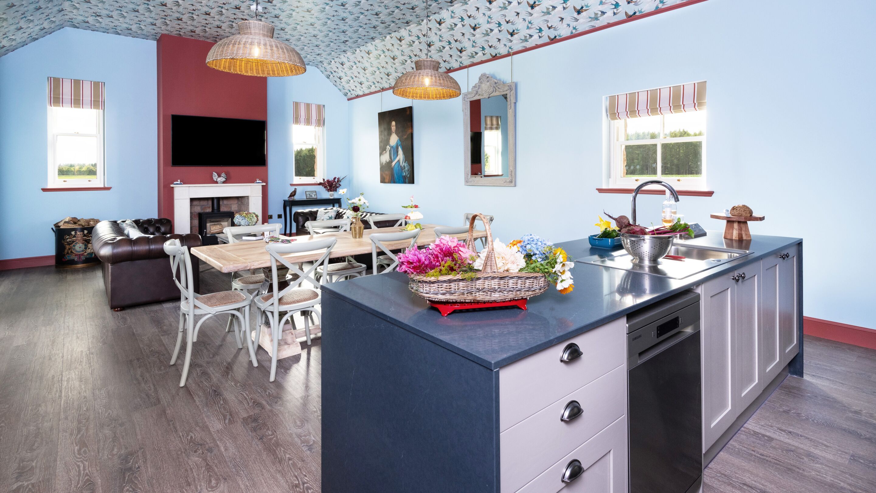 A spacious living room with a fireplace, a dining area, and a kitchen with a large island.