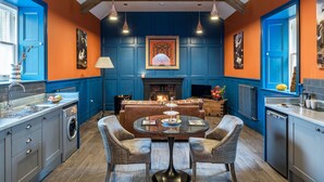 Een keuken met een eethoek, een open haard en een kleurenschema van blauw en oranje.