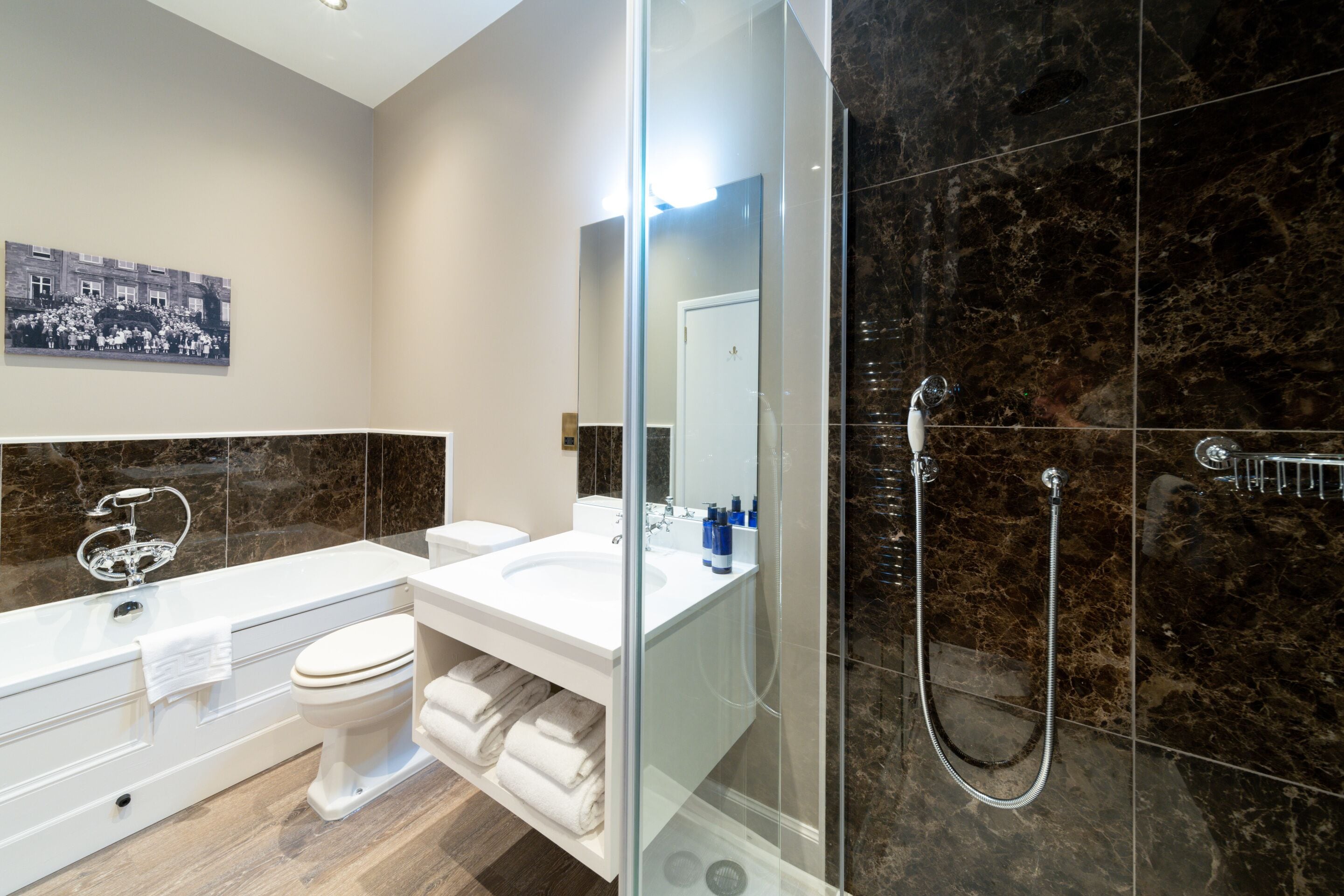 A modern bathroom with a glass-enclosed shower, a white sink, and a toilet.
