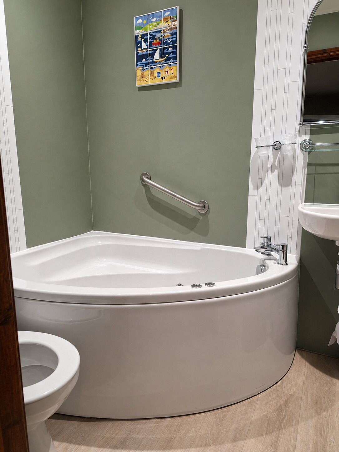 A bathroom with a bathtub, toilet, and a wall-mounted sink.
