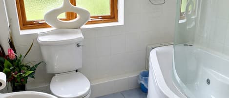 A bathroom with a toilet, sink, and bathtub.