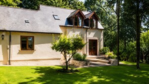 A house with a sloped roof, a front door, and a small window. - Little Red Rooster Rest and Spa (Tenby)