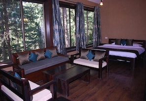 Una habitación con sofá, cama y ventana con cortinas.