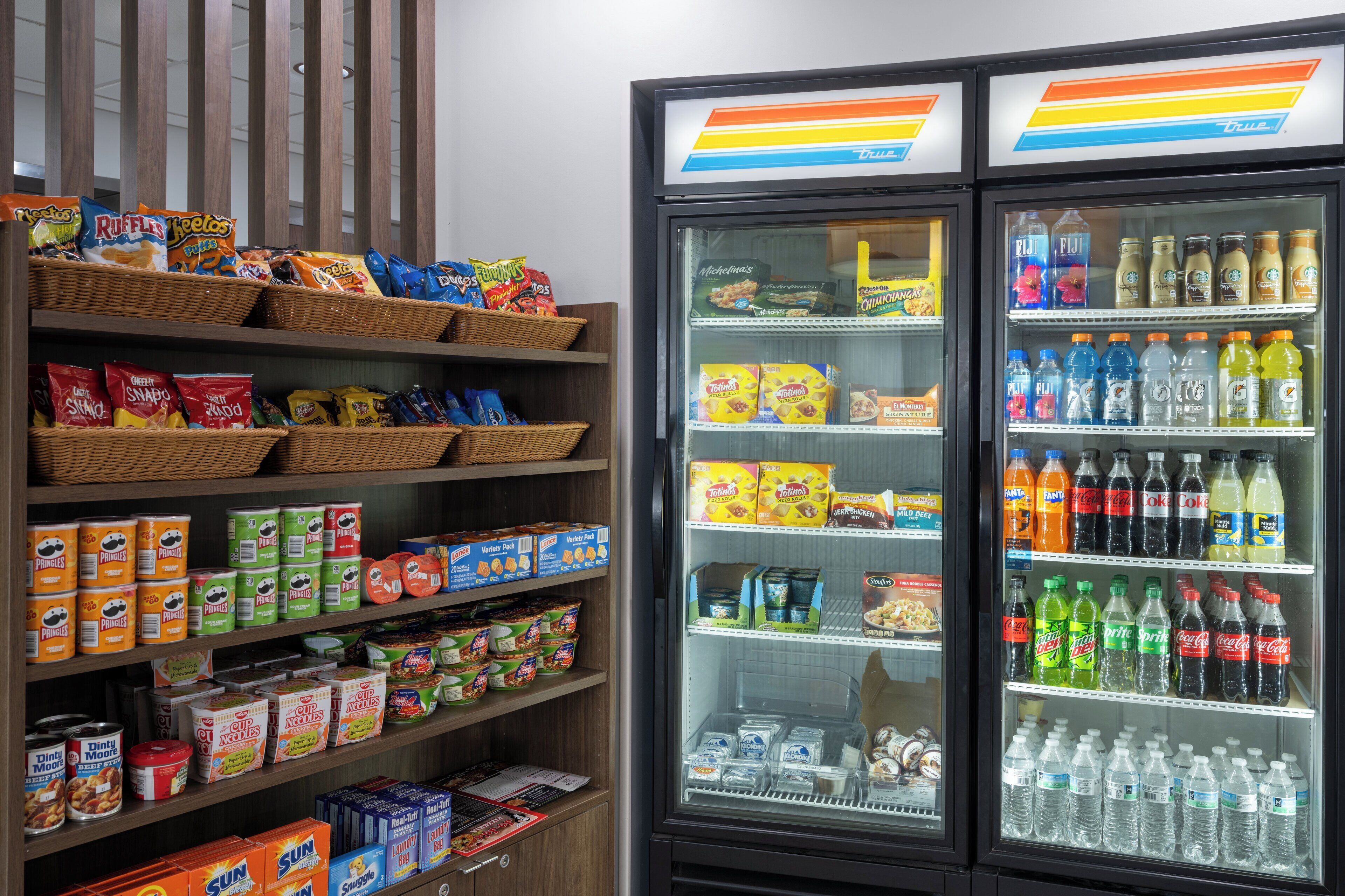 A snack and beverage display in a store, including chips, cereals, and bottled drinks.
