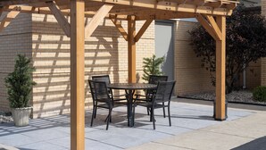 A wooden pergola with a table and chairs in an outdoor patio area. - Holiday Inn Express Toledo North by IHG (Toledo)