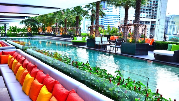 A rooftop pool area with seating and greenery, surrounded by modern buildings. - Holiday Inn Bangkok Sukhumvit by IHG (Bangkok)