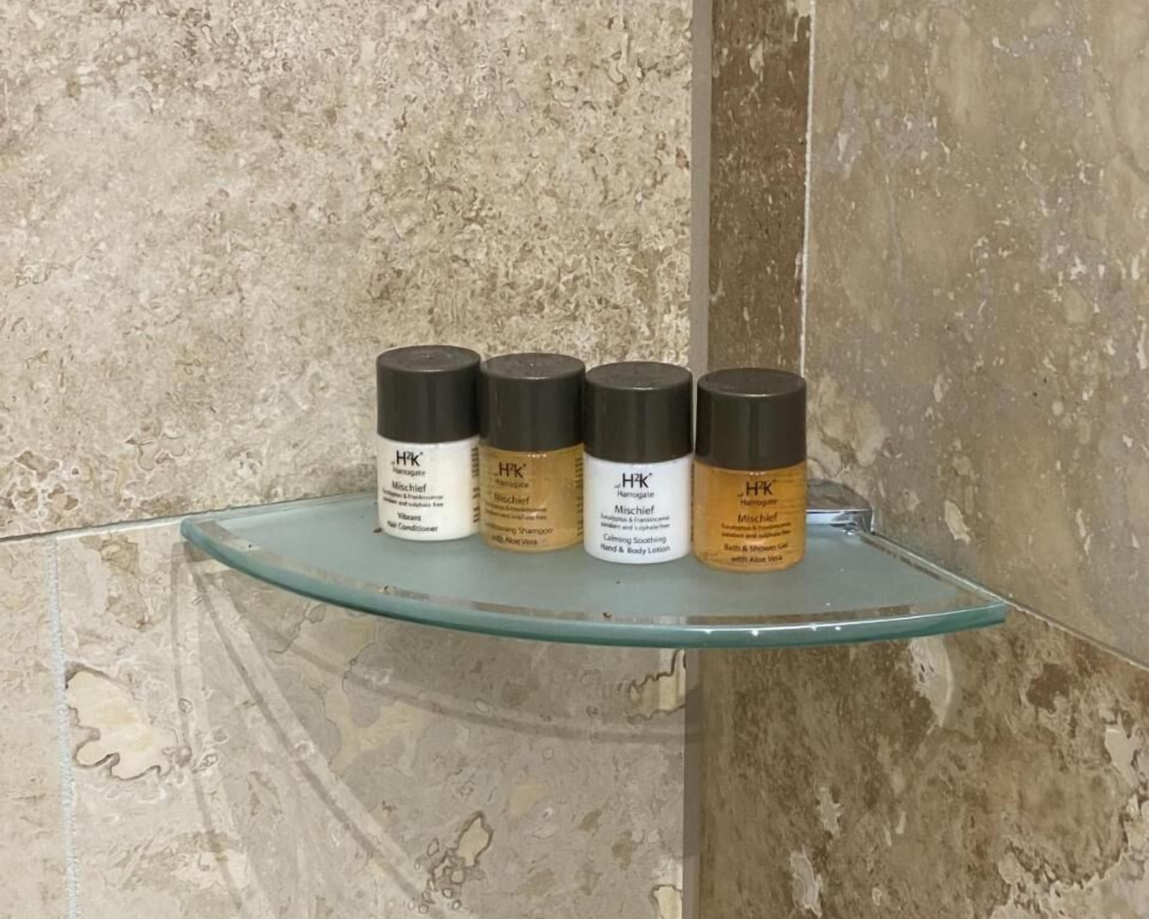 A bathroom shelf with four H&K Mischief skincare products.
