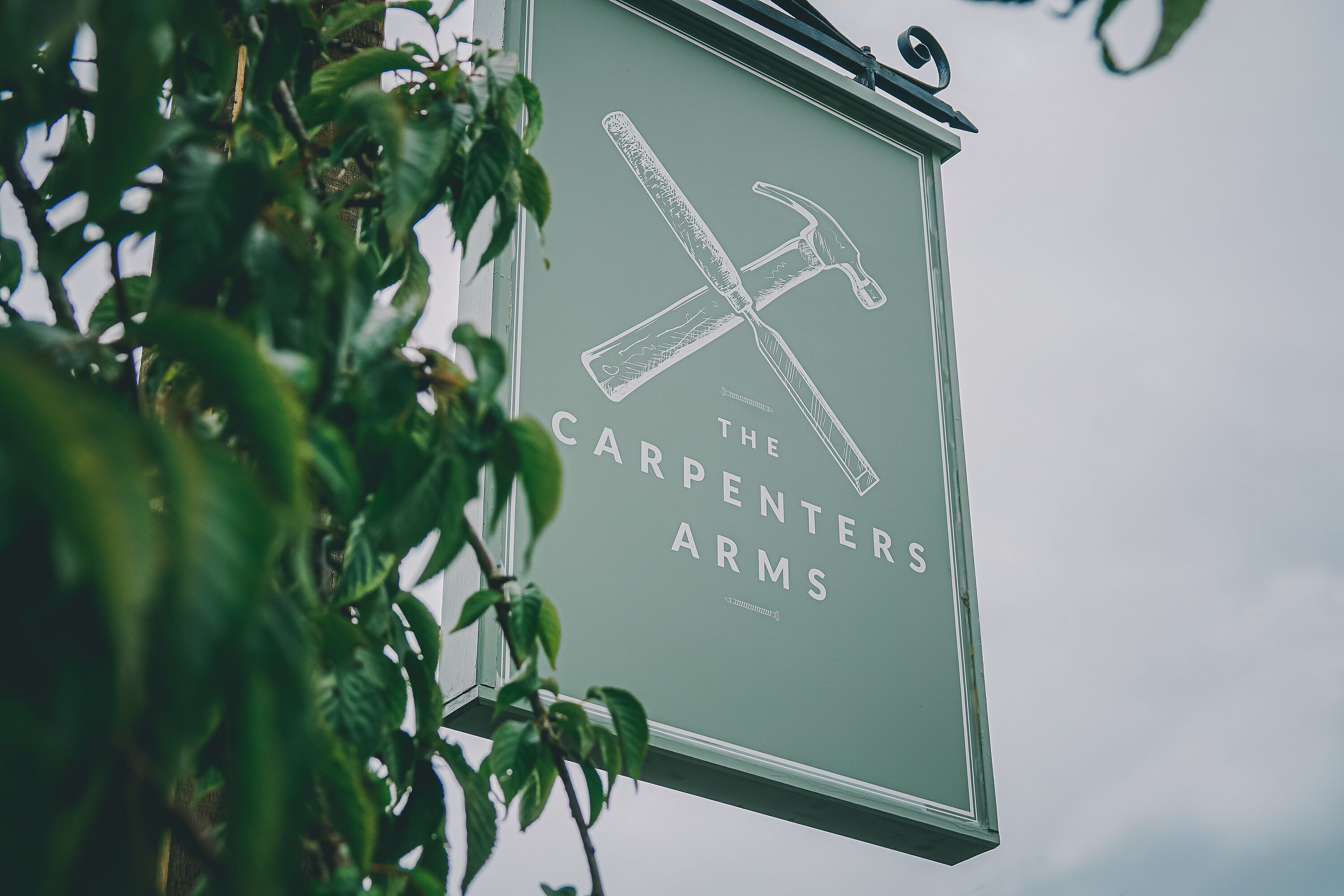 A sign with a hammer and a saw, indicating a carpentry or woodworking business.