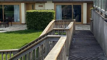 A hotel with a covered outdoor area, a wooden deck, and a grassy lawn.