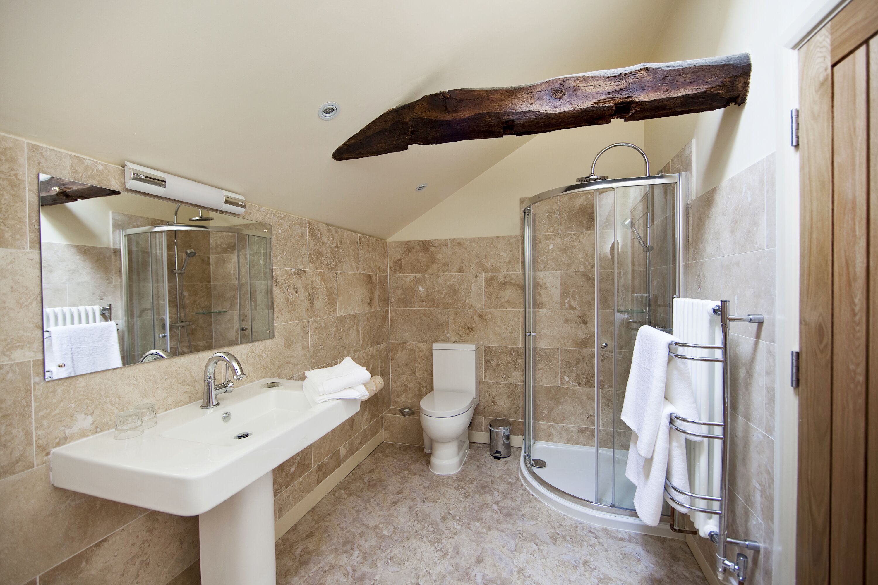 A bathroom with a sink, toilet, and glass shower enclosure.