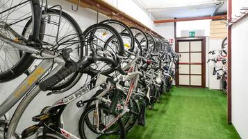 A row of bicycles parked against a wall in a room with green carpet.