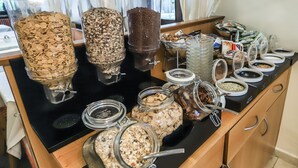 A buffet with various food items in jars and containers. - Hotel Villa Groff (Ora)