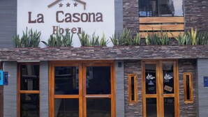 The exterior of La Casona Hotel with a stone facade, wooden entrance doors, and a sign above the entrance. - Hotel La Casona (Iquitos)