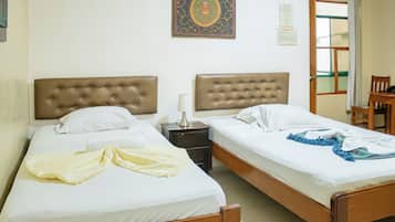 Una cama doble con cabecera de madera, una mesita de noche con lámpara y un adorno en la pared.