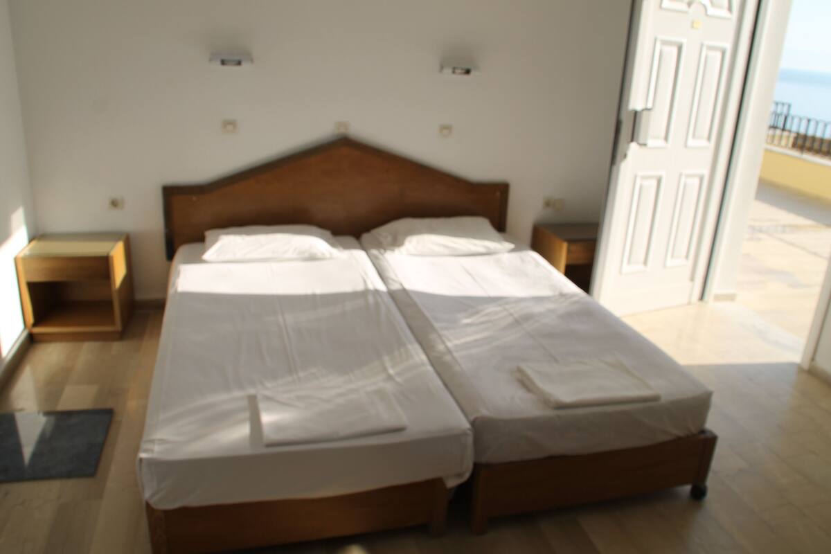 A double bed with a wooden headboard in a hotel room.