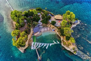 An aerial view of a small island with a beach, a gazebo, and a boat dock. - Alba Hotel (Zakynthos)