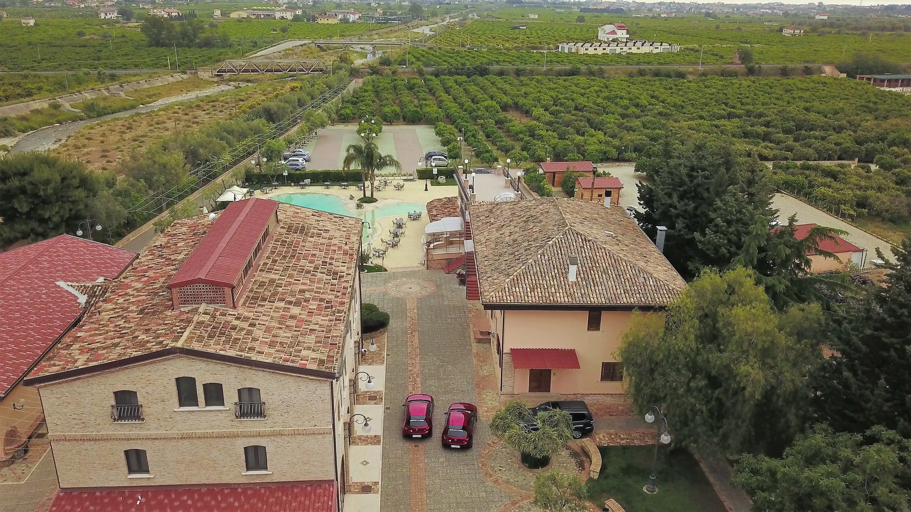 Zona residencial con casas de techo en teja roja, piscina y jardín.