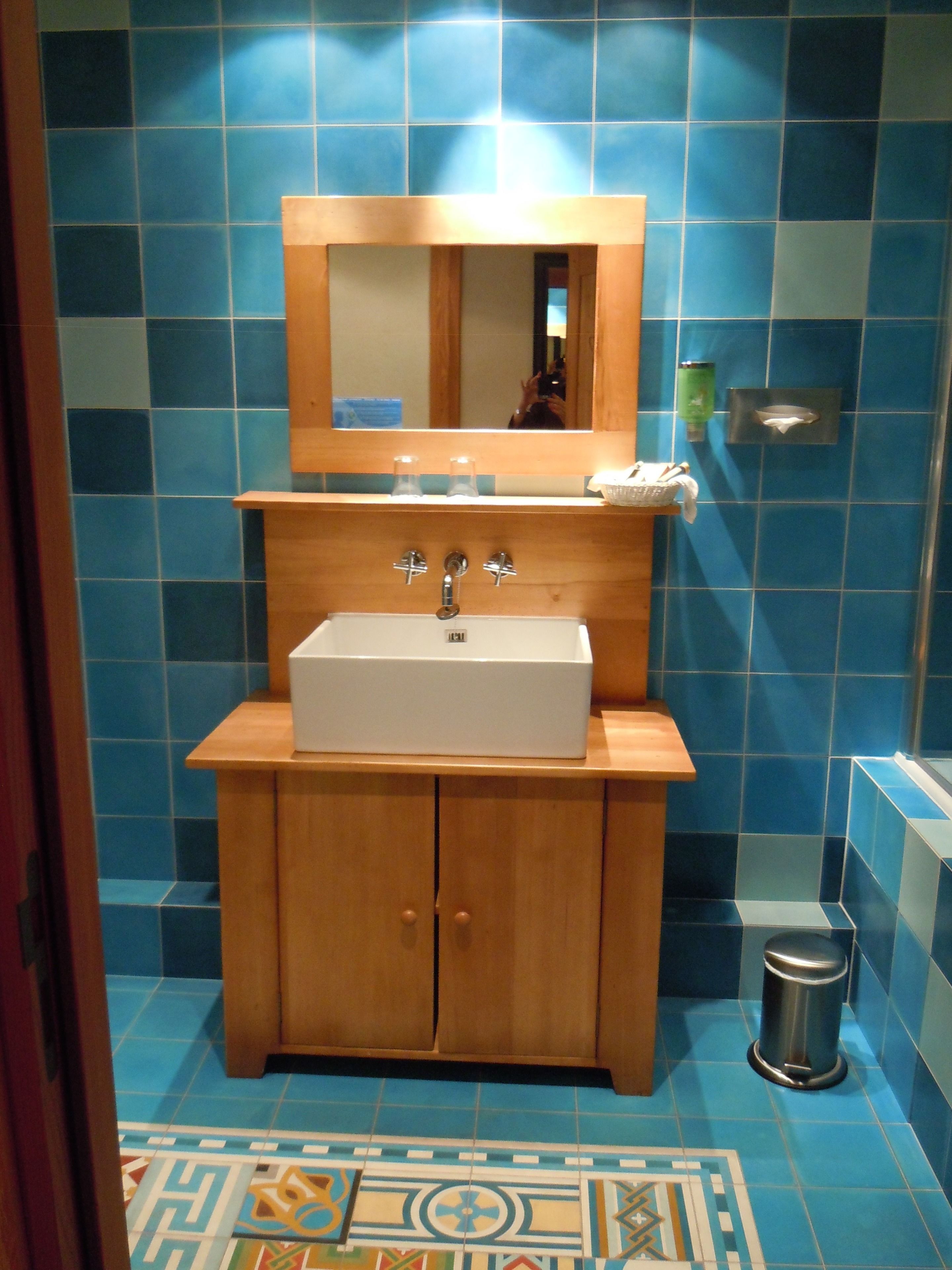 Une salle de bain avec un meuble-lavabo en bois, un lavabo blanc et un miroir au-dessus.