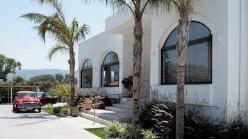 A modern building with arched windows and a concrete driveway.