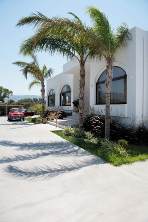 A modern building with arched windows and a concrete driveway. - Summer Village of Hippokrates (Kos)