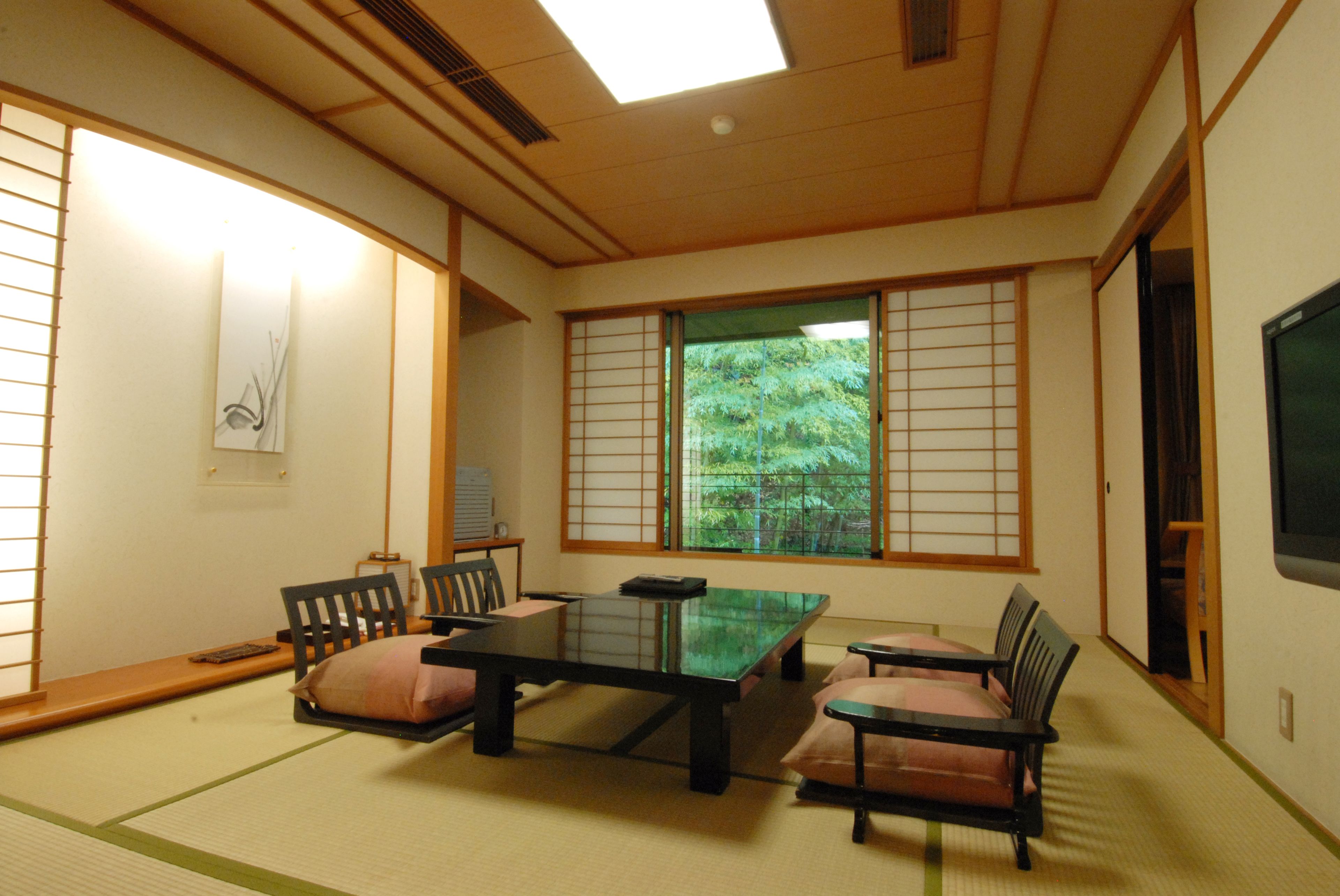 A traditional Japanese room with tatami flooring, a low table, and sliding doors.