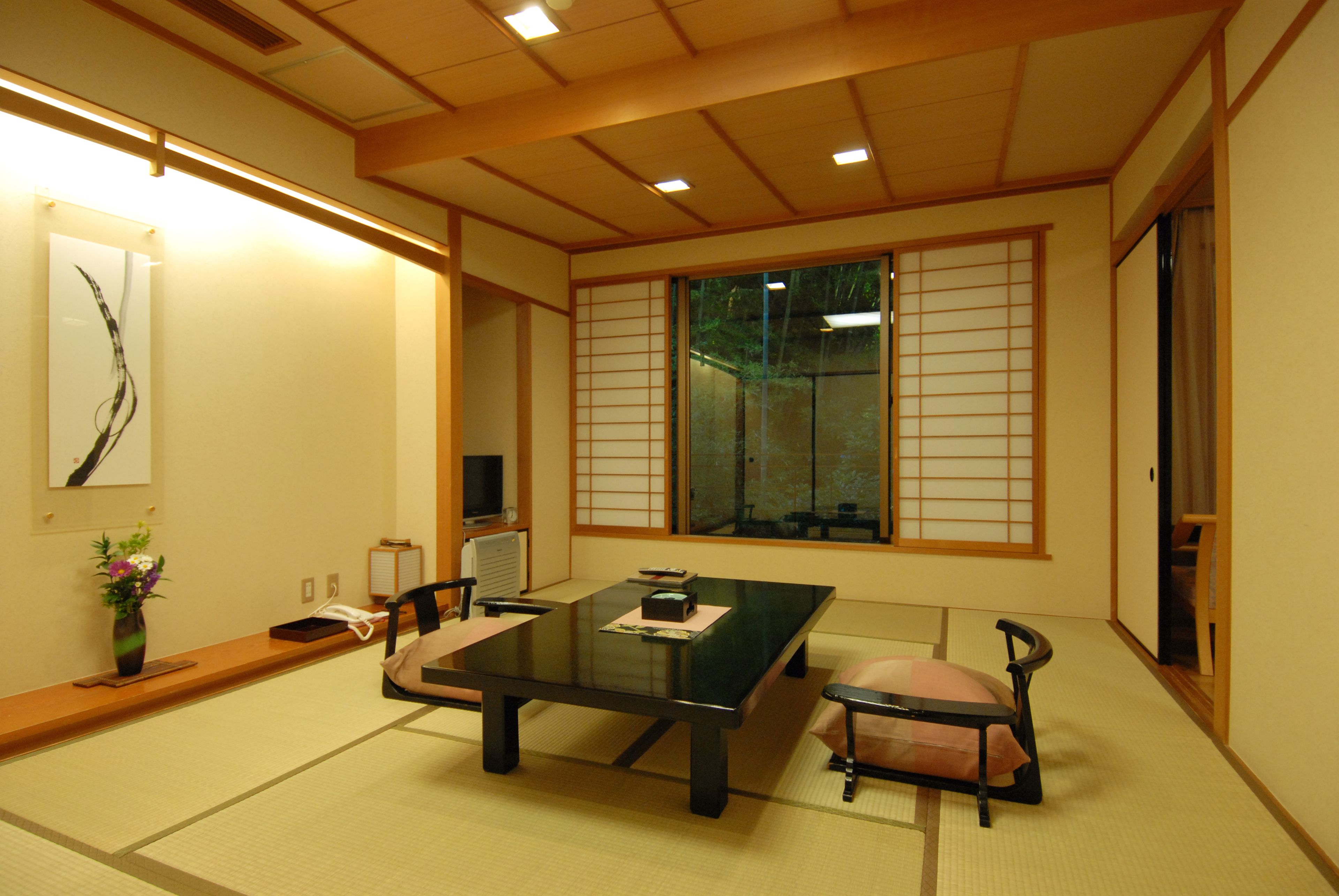 A traditional Japanese room with tatami flooring, a low table, and shoji screens.