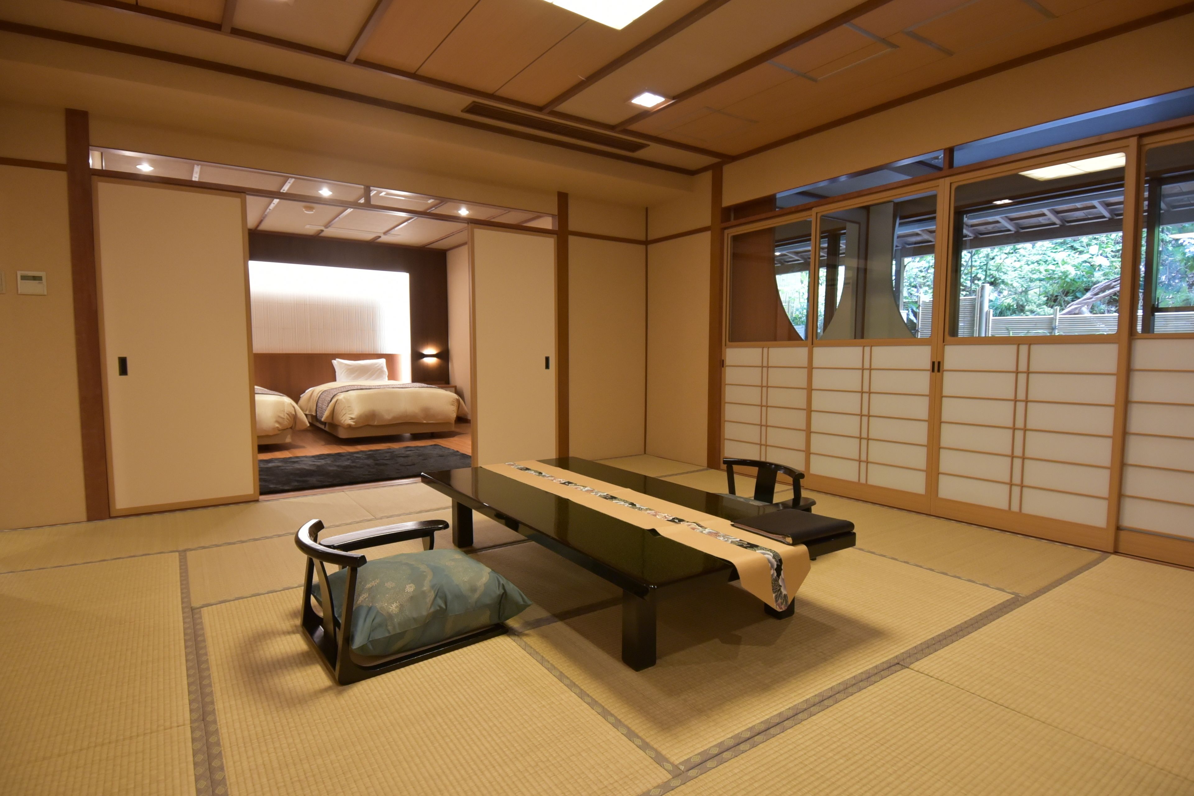 A traditional Japanese room with tatami flooring, a low table, and sliding doors.