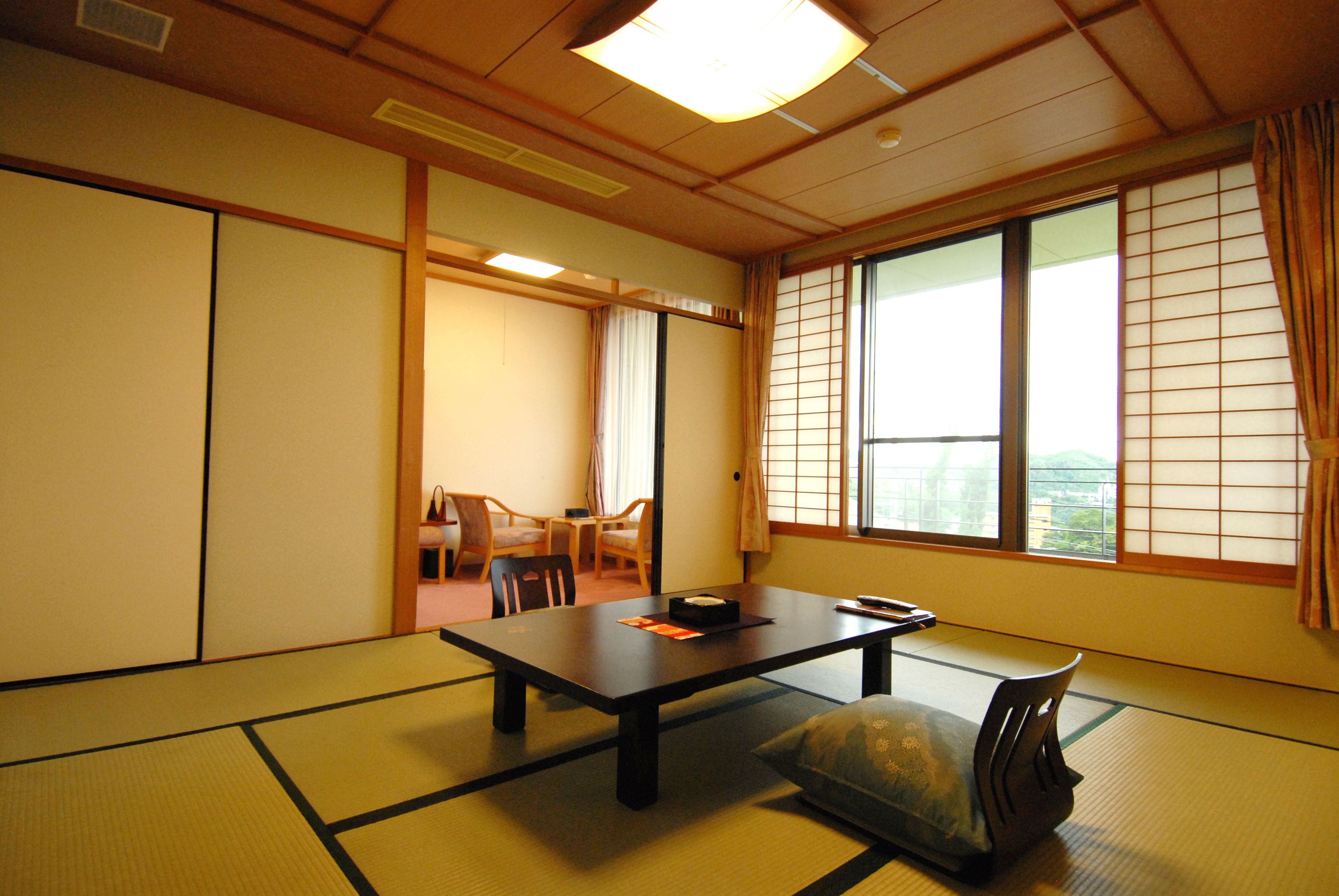 A traditional Japanese room with tatami flooring, a low table, and sliding doors.