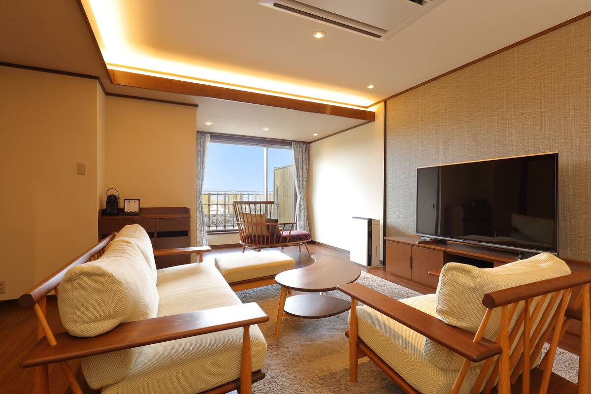 Una sala de estar moderna con un conjunto de sofá, una mesa de centro y un televisor de pantalla plana.