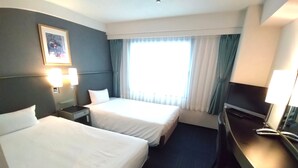 A hotel room with two beds, a desk, a chair, a TV, and a window with curtains. - Grand Central Hotel (Tokyo)