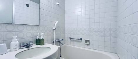 Een badkamer met een wit wastafel, spiegel en bad.