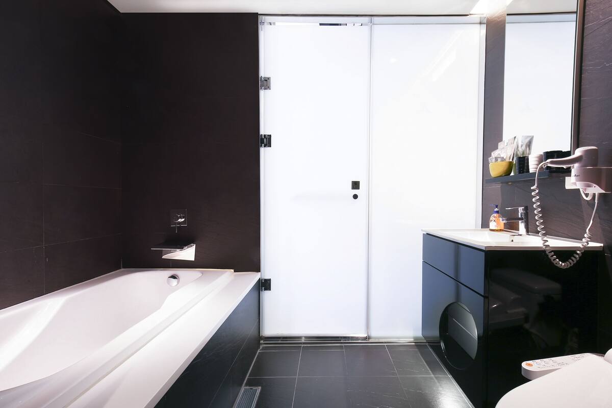 deluxe triple room, bathtub, city view | bathroom | shower, hair dryer, slippers, towels
