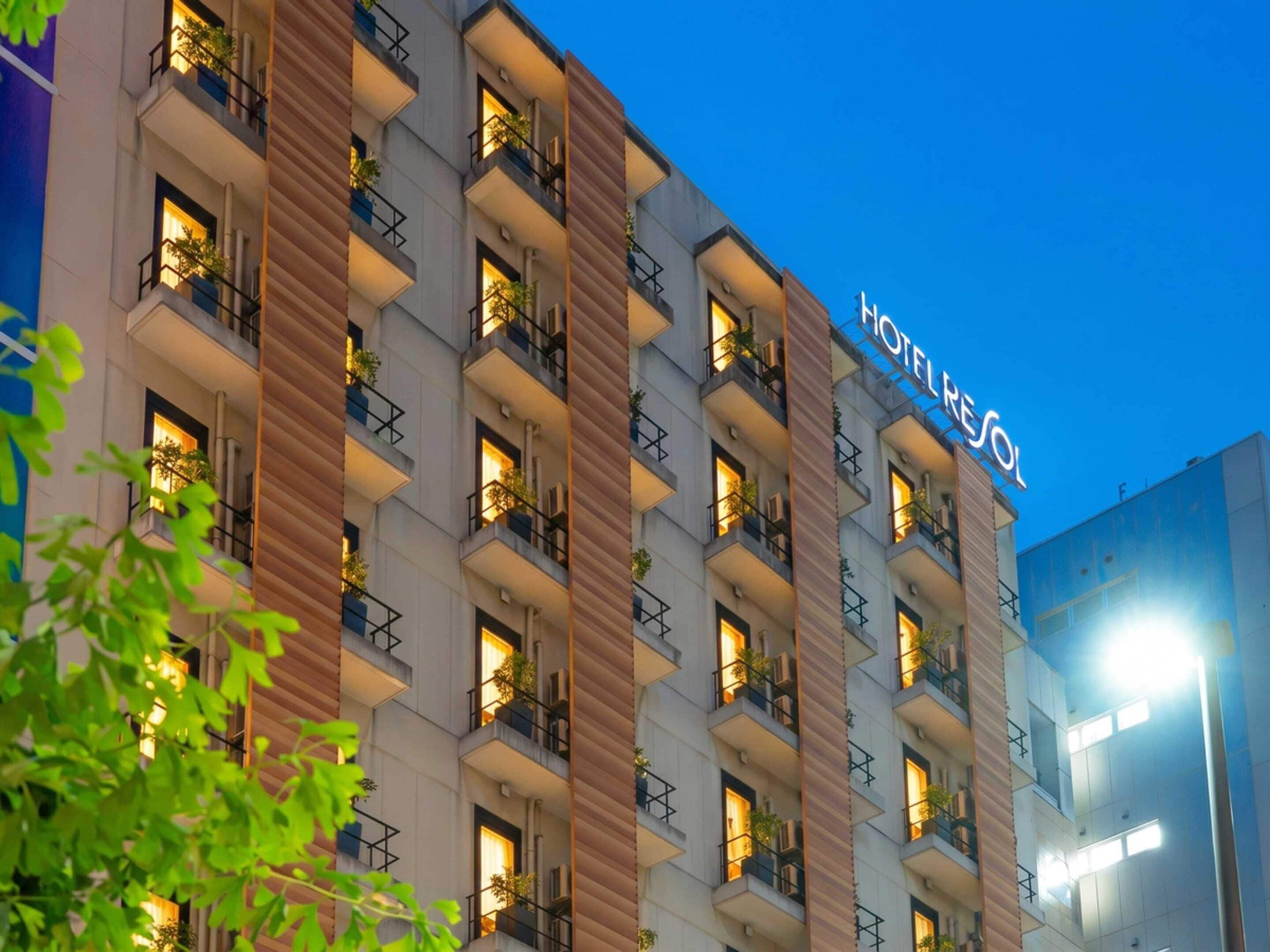 A multi-story hotel with balconies, a prominent sign, and a night sky.