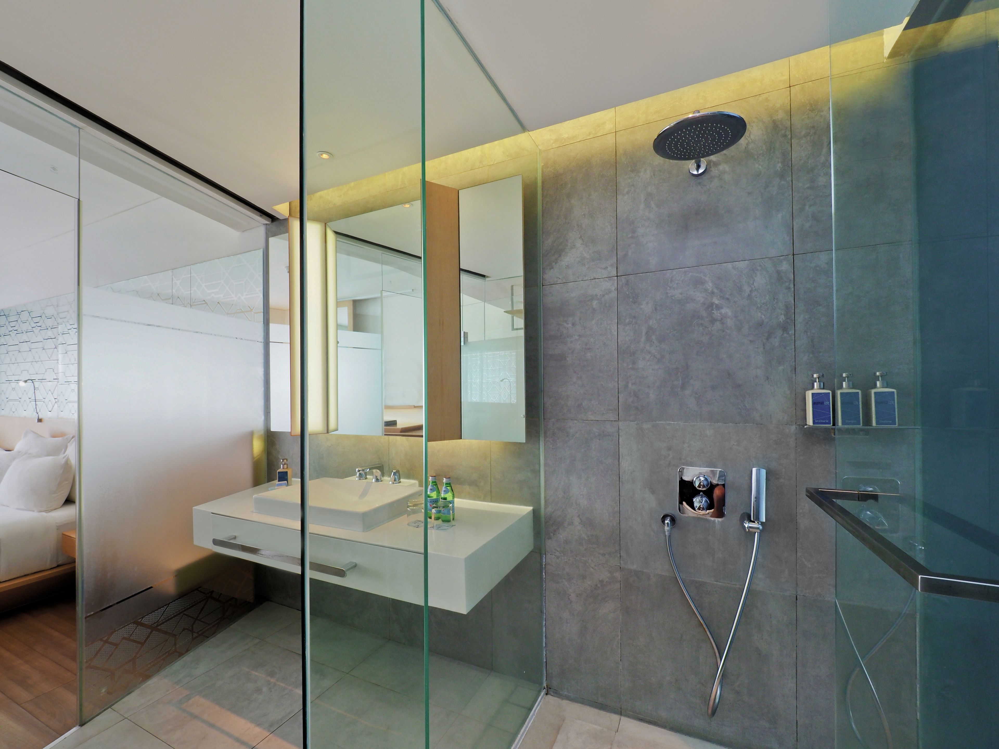 A modern bathroom with a glass shower enclosure, a vanity with a double sink, and a large mirror.