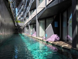Um hotel moderno com piscina, janelas amplas e design limpo e contemporâneo.