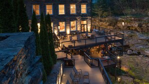 A multi-story building with a deck and outdoor seating area, surrounded by natural landscape. - Ledges Hotel (Hawley)