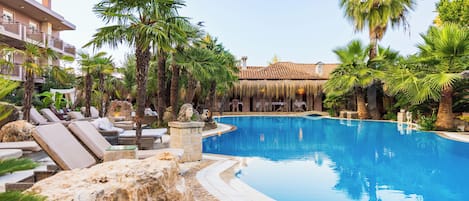 Una piscina al aire libre de temporada, sombrillas