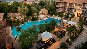 A resort with a large swimming pool surrounded by lounge areas and outdoor seating. - Achtis Boutique Hotel (Kassandra)