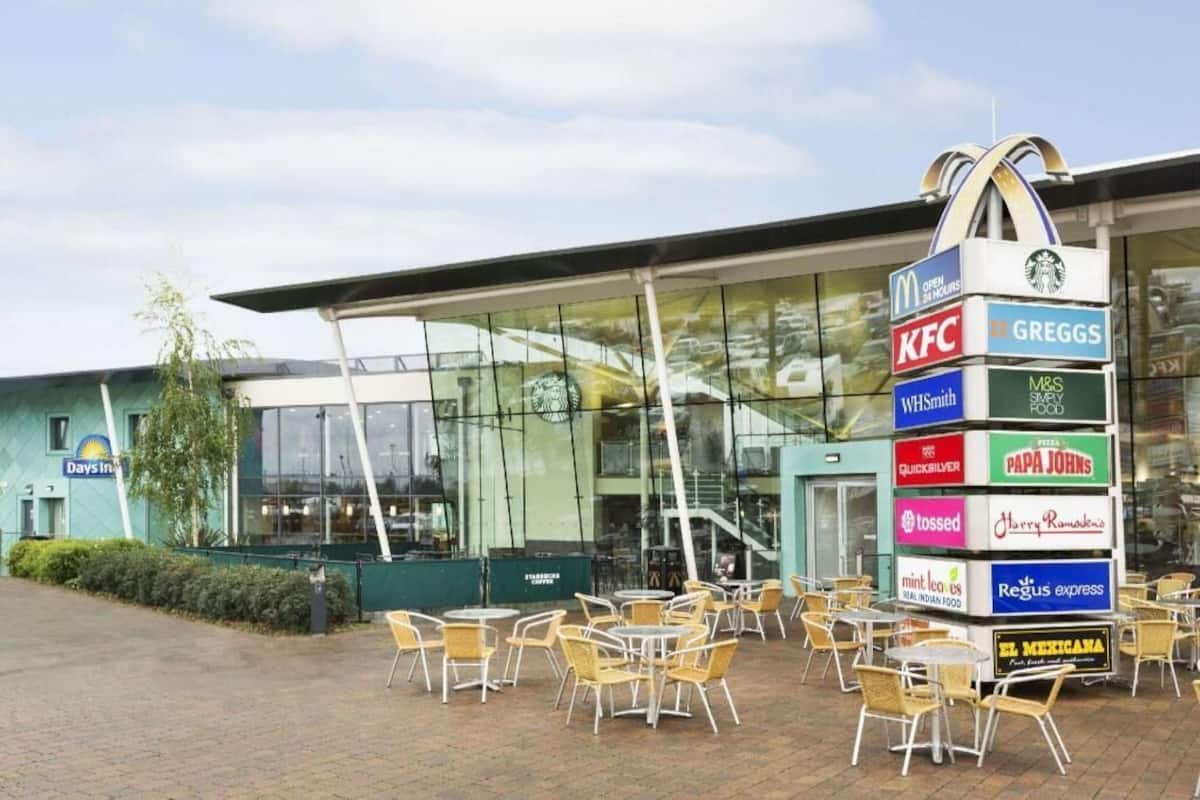 A building with a glass facade and outdoor seating area.