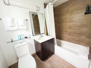 Une salle de bain moderne équipée de toilettes, d’un lavabo et d’une baignoire.