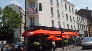 A hotel with a sign reading "HOTEL OUVERT" and a storefront with red awnings. - Café hôtel de l'Avenir (Saint-Ouen)