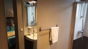A bathroom with a sink, mirror, towel rack, and shower. - Café hôtel de l'Avenir (Saint-Ouen)