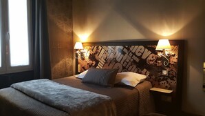 A hotel room with a large bed, two bedside lamps, and a wall with a textured design. - Café hôtel de l'Avenir (Saint-Ouen)