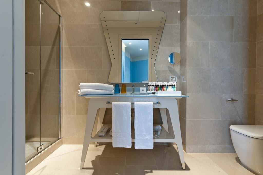 A modern bathroom with a glass shower enclosure, a white vanity with a mirror, and a toilet.