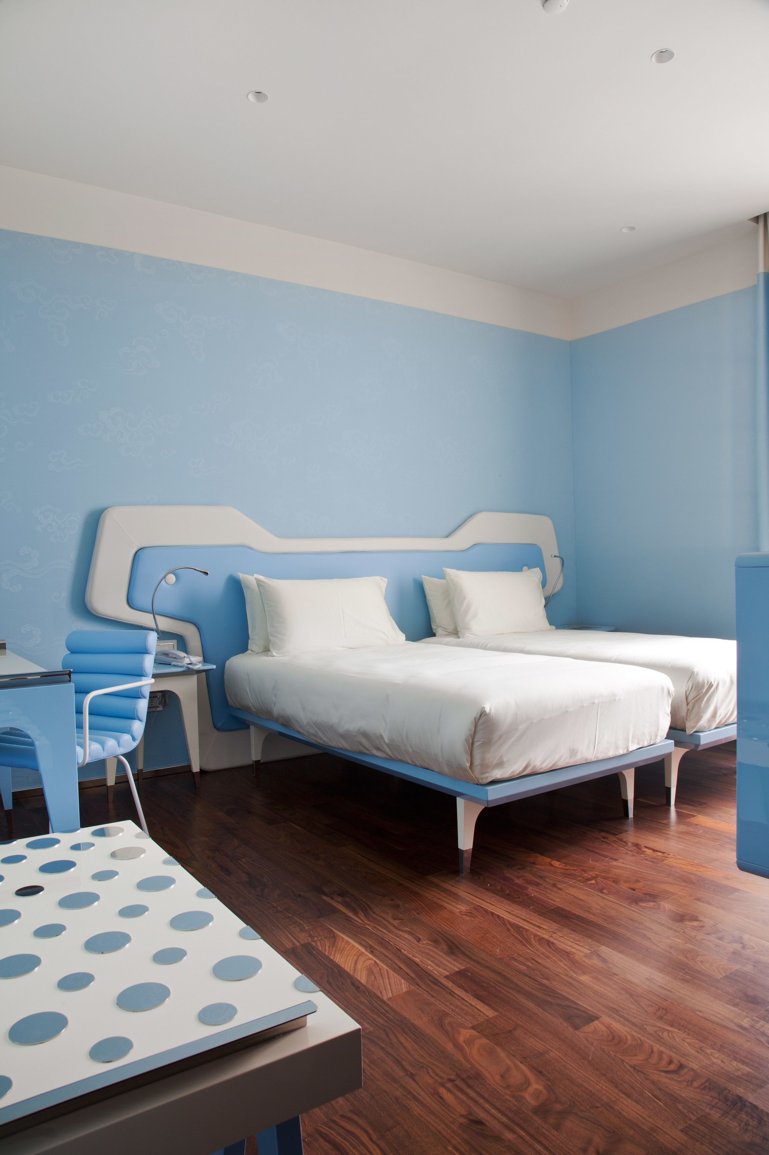 Una camera da letto con un letto, un comodino e una scrivania con una sedia.