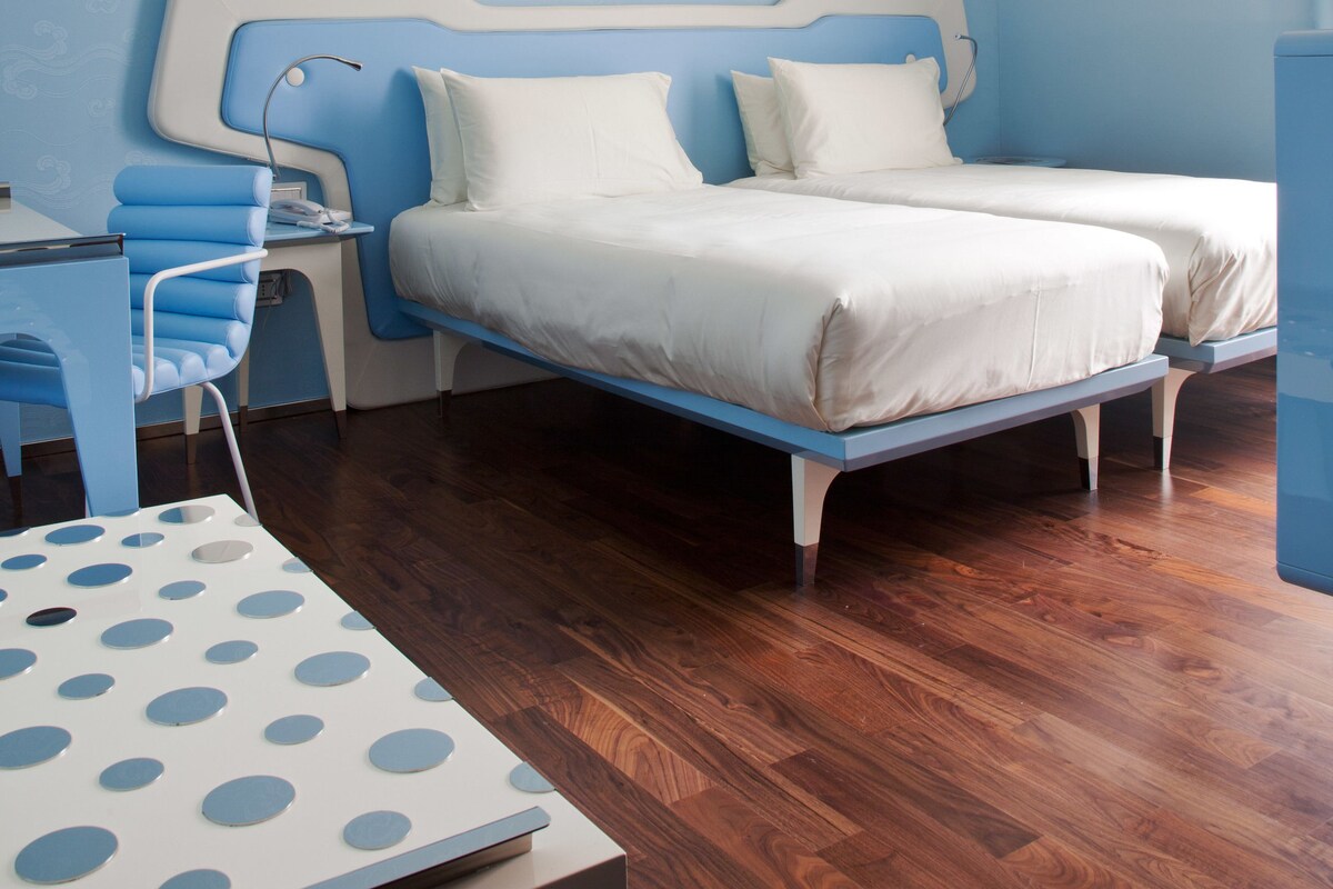 Une chambre à coucher comprenant un lit, une table de chevet et un bureau avec une chaise.