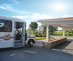 A white bus with a Bird-in-Hand Inn logo parked at a motel's gas station.
