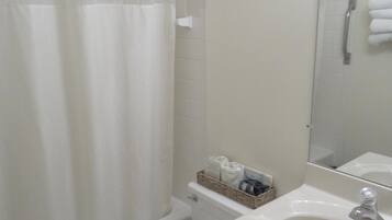 A bathroom with a shower curtain, toilet, and sink.