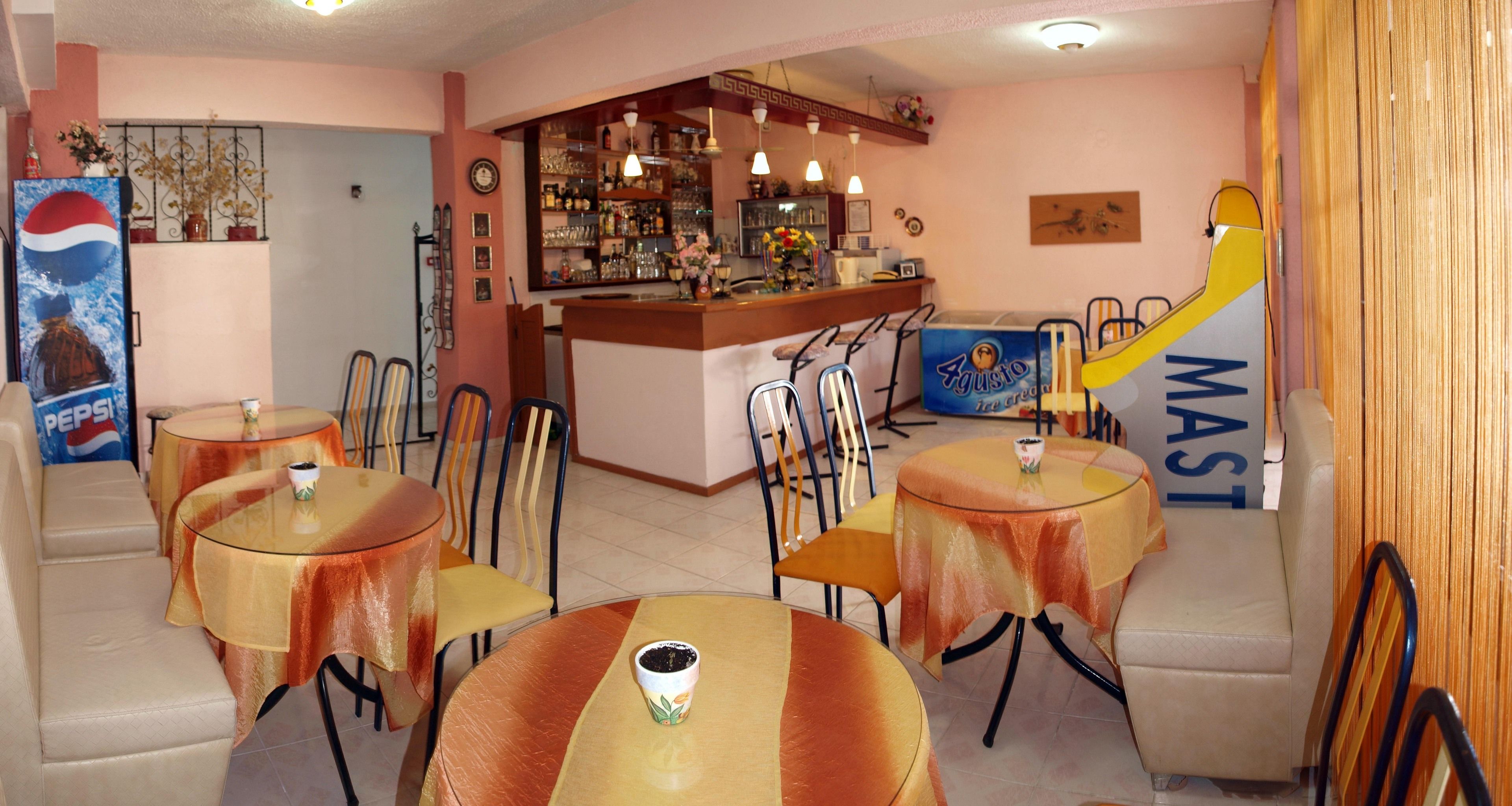 A bar area with a counter, chairs, and tables.