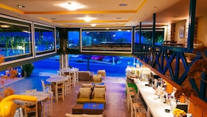 Ein Restaurant mit Außenbereich, einer Bar und großen Fenstern mit Blick auf einen Parkplatz.